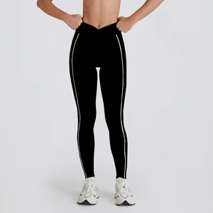 Detail of high-waisted yoga leggings with crossover waistband and green side stripes