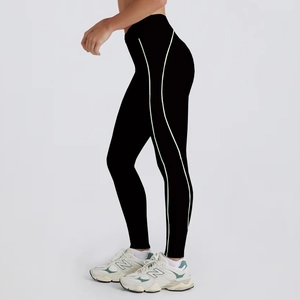 Side view of high-waist black yoga leggings with light green curved contour stitching