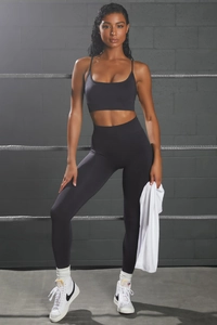 Detail of black seamless yoga set with high waist leggings and thin strap sports bra