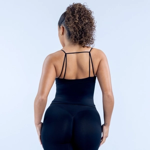 Détail des bretelles croisées d'un soutien-gorge de sport noir et d'un legging assorti