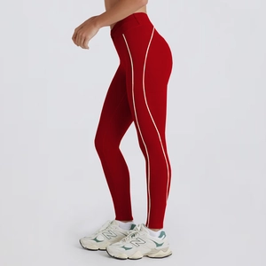 Detail view of high-waist red yoga leggings with athletic white side stripe design