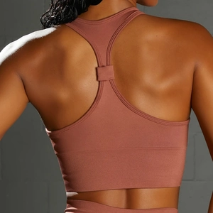 Detail of racerback sports bra in dusty rose featuring ribbed texture and wide hem