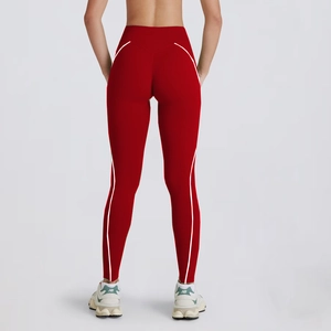 Detail view of red high-waisted yoga leggings with white side stripes and slim fit design