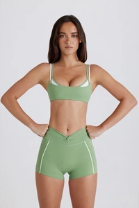 Conjunto de yoga verde hierba con sujetador deportivo y pantalones cortos de talle alto