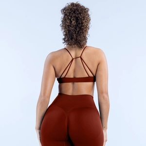 Detailansicht des ziegelroten Sport-BHs mit Kreuzrücken und nahtloser Leggings für Damen