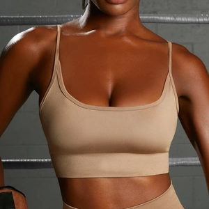 Detail of seamless khaki sports bra with thin straps and ribbed band in gym setting