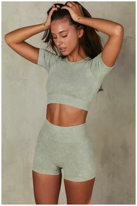 Détail d'un ensemble de yoga vert délavé avec haut court côtelé et short à taille haute
