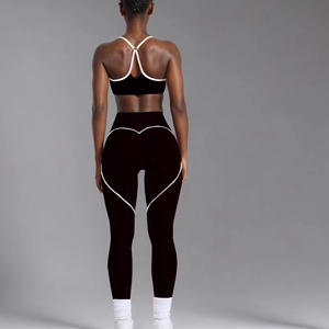 Women's black yoga set with heart-shaped stitching on leggings and sports bra
