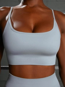 Detail of light blue seamless yoga bra showing rib knit texture and U-neckline on model