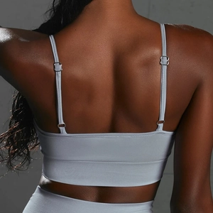 Close-up of seamless light grey sports bra with adjustable thin straps and ribbed band