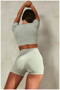 Vue arrière de l'ensemble de yoga sans couture vert sauge avec haut court et short délavé