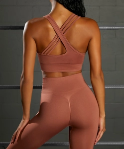 Detail of cross-back sports bra and high-waisted seamless leggings in rose pink