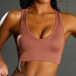 Detail of dusty pink seamless sports bra with V-neck and ribbed hem for fitness training