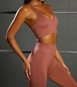 Detail of seamless terracotta yoga set showing cross back sports bra and high waist leggings