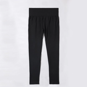 Flat lay detail of high waisted seamless black yoga pants with a wide compression waistband