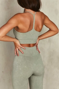 Dettaglio del reggiseno sportivo e leggings yoga senza cuciture verde salvia effetto acido