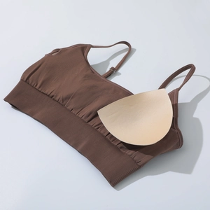 Detail view of brown yoga sports bra featuring thin straps and removable beige pads