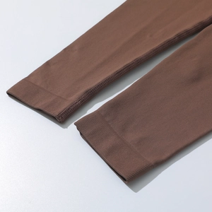 Detailed view of brown ribbed knit fabric and reinforced cuffs on high-stretch yoga set
