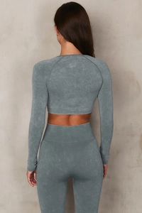 Dettaglio dei leggings da yoga senza cuciture a vita alta e crop top in blu grigio lavato