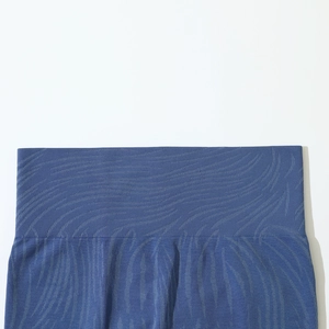 Close-up of seamless ribbed high waistband on navy blue yoga shorts with wave pattern