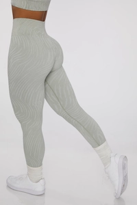 Detail of high-waisted seamless yoga leggings with light green tiger stripe pattern