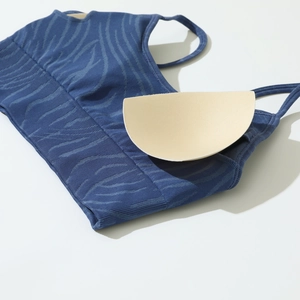 Detail of dark blue sports bra showing seamless knit fabric and removable chest pads