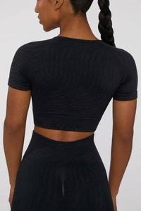 Back view of wave texture black yoga set featuring short sleeve crop top and high waist leggings