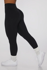 Detail view of black high-waisted yoga leggings with wave texture and scrunch butt design