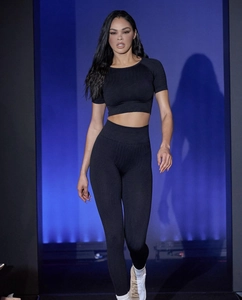 Detail of a seamless black high-waist ribbed yoga set on a model with studio lighting