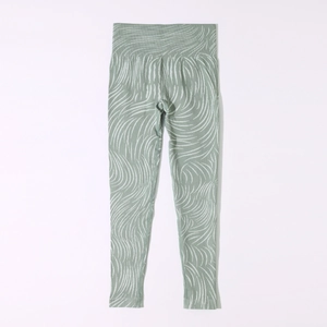 Detail of sage green seamless yoga pants with white abstract wave pattern texture