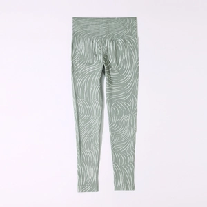 Close-up of seamless high-waist yoga pants with green wavy pattern and scrunch butt detail