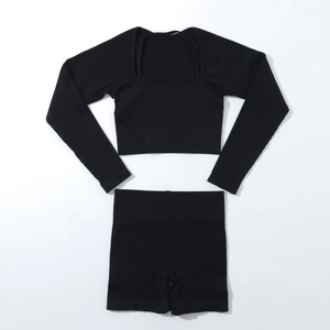 Flat lay of seamless black ribbed knit yoga set including long sleeve top and high waist shorts
