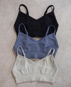 Flat lay detail of rib-knit seamless yoga bras in black, blue-grey and beige colors