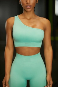 Dettaglio del set yoga verde menta senza cuciture con reggiseno monospalla e leggings