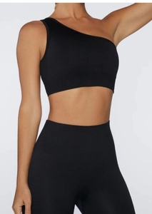 Dettaglio del reggiseno sportivo monospalla nero e set di leggings senza cuciture