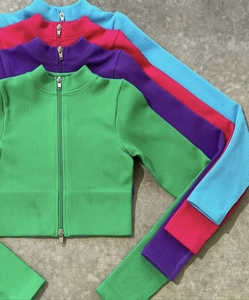 Détail de crop tops en maille côtelée avec doubles zips métalliques colorés