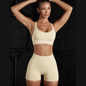 Detail of seamless halter neck sports bra and high-waisted shorts in pale yellow