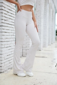 Macro detail of ribbed knit texture on high-waist flared yoga pants in light grey