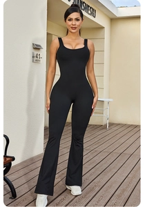 Outdoor shot of sleeveless black backless jumpsuit with flared pants for yoga and casual wear