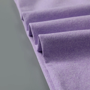 Vue macro du tissu de yoga sans couture violet foncé avec texture sergé et drapé doux