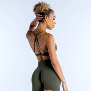 Detail of cross-back sports bra and high-waisted shorts in deep green stretch fabric