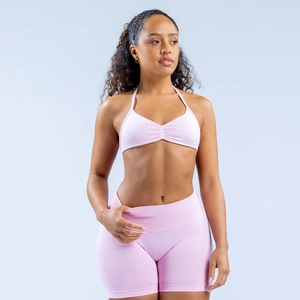 Pink halter neck sports bra and yoga shorts set on model in high-elastic matte fabric