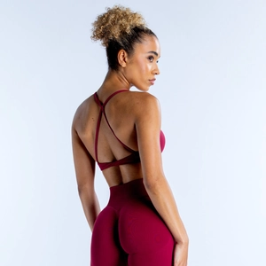 Detail of burgundy backless sports bra with criss-cross straps and high waist leggings