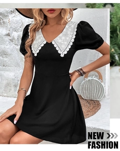 Détail du col en V brodé blanc et des manches bouffantes sur une robe d'été noire