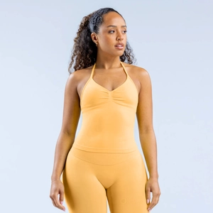 Détail du débardeur de yoga licou jaune moutarde avec encolure plissée et tissu respirant
