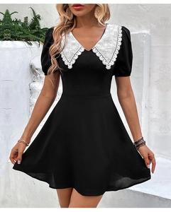 Vue détaillée du col Claudine en dentelle blanche sur une robe noire à manches courtes
