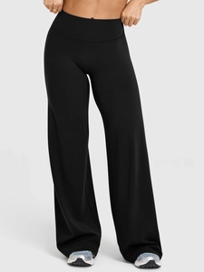 Detail view of high waist black yoga pants with wide-leg cut and elastic knitted fabric
