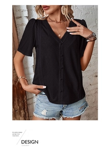 Close-up of black V-neck shirt featuring geometric eyelet embroidery and lace details