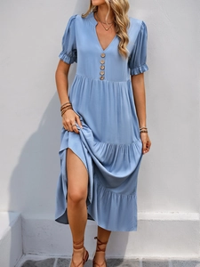 Detail of light blue V-neck dress featuring wooden buttons and layered ruffle sleeves