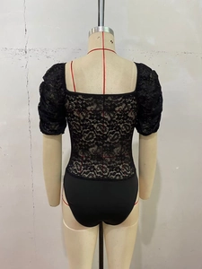 Gedetailleerd achteraanzicht van een zwarte kanten bodysuit met pofmouwen en mesh textuur